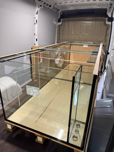 Großes Aquarienbecken mit Holzverkleidung in einem modernen Wohnraum.