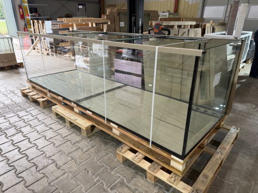 Großes Aquarienbecken mit Holzverkleidung in einem modernen Wohnraum.