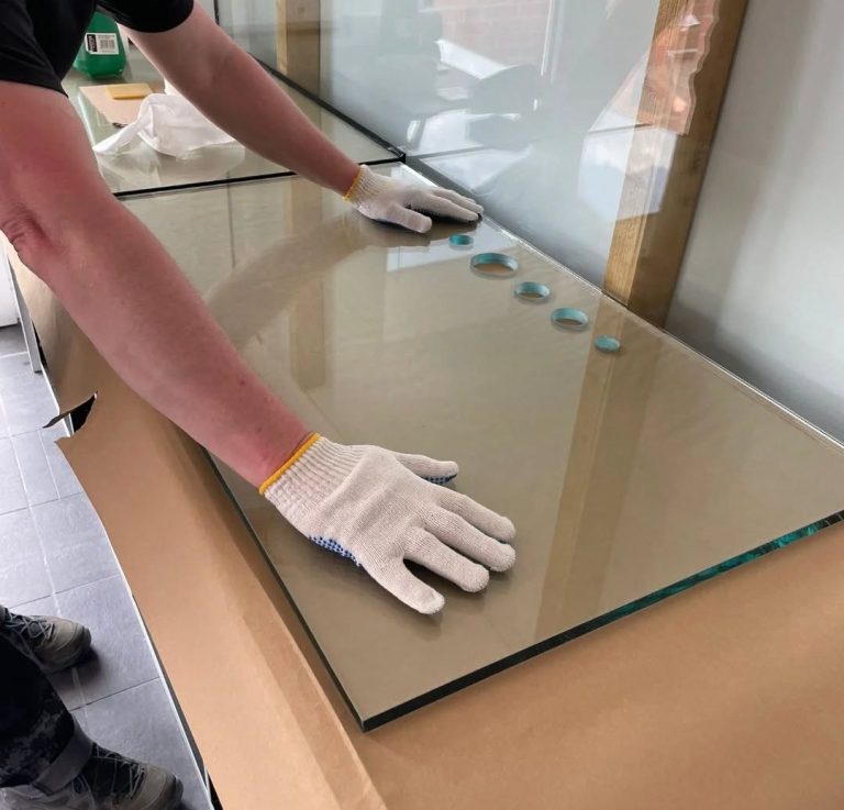 Handwerker verklebt Glasscheiben zu einem Aquarium zusammen